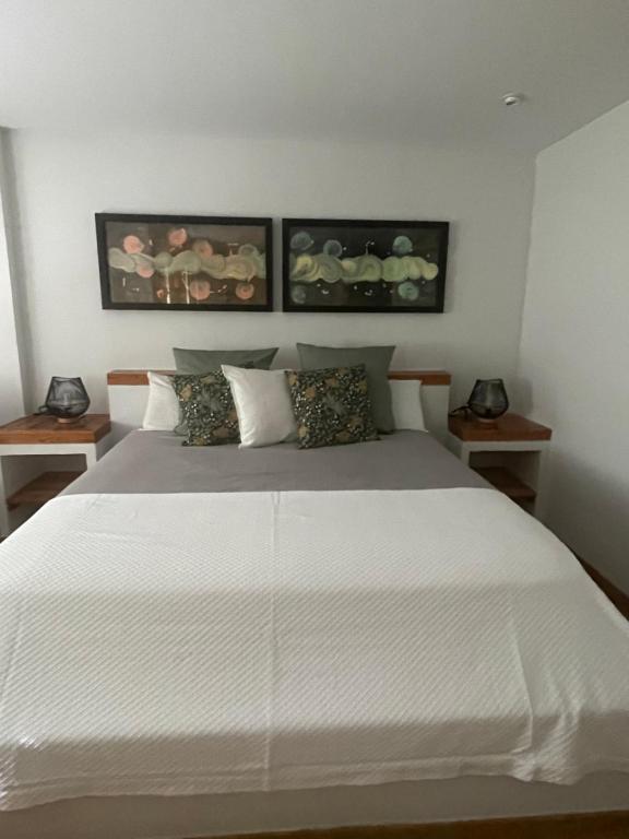 1 dormitorio con 1 cama blanca grande y 2 mesas en Good Vives Free SL, en Madrid