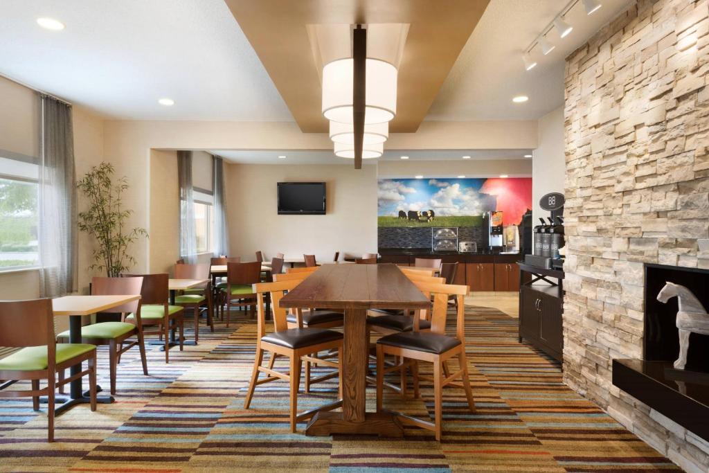 comedor con mesas y sillas y pared de piedra en Fairfield Inn Kankakee Bourbonnais, en Bourbonnais