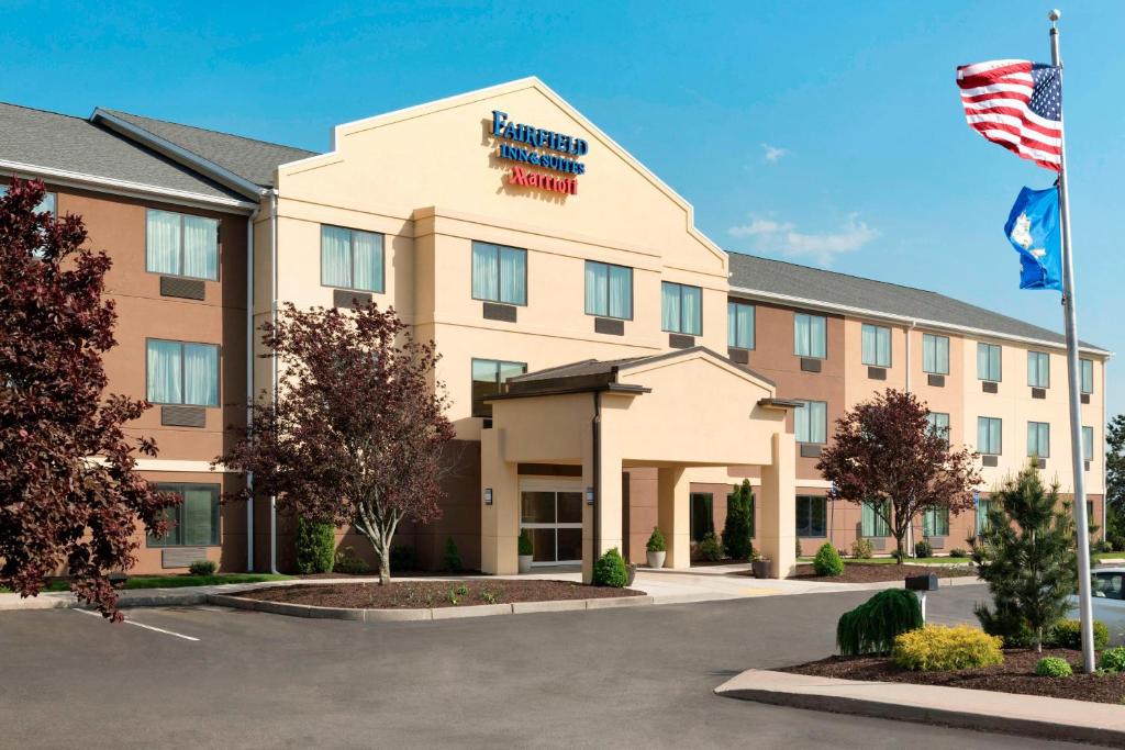 an exterior view of a hotel with an american flag at Fairfield Inn & Suites Hartford Manchester in Manchester