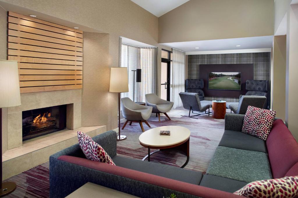 a living room with a couch and a fireplace at Courtyard by Marriott Fayetteville in Fayetteville