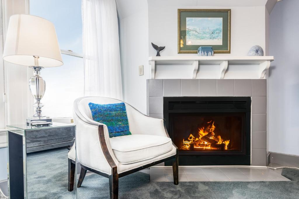 a living room with a chair and a fireplace at Nantucket Whale Inn, Half Moon Bay in Half Moon Bay