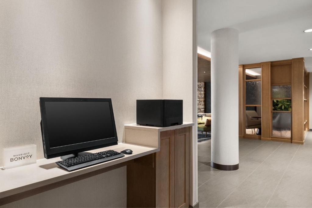 a computer monitor and a keyboard and mouse on a desk at Fairfield by Marriott Inn & Suites Bonita Springs in Bonita Springs