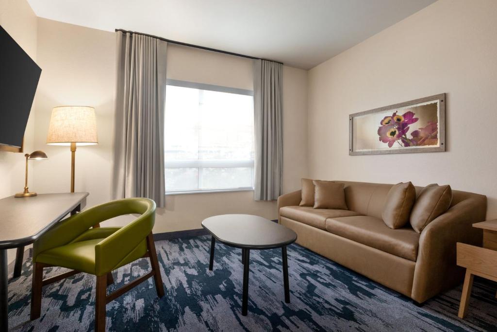 a living room with a couch and a table at Fairfield by Marriott Inn & Suites Bonita Springs in Bonita Springs