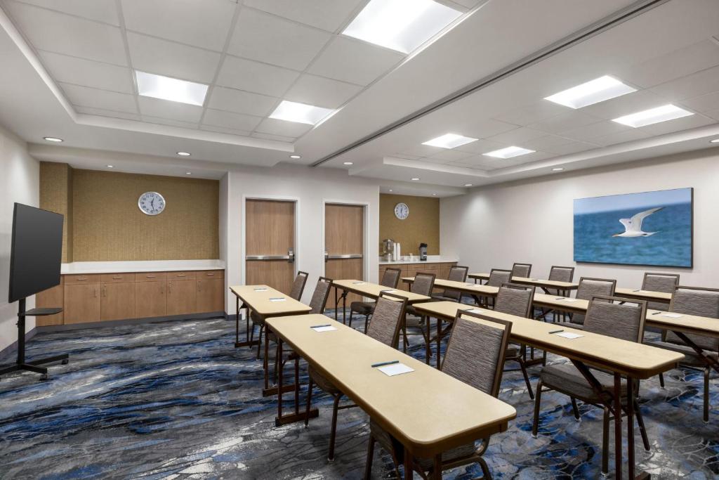 a classroom with tables and chairs and a screen at Fairfield by Marriott Inn & Suites Bonita Springs in Bonita Springs