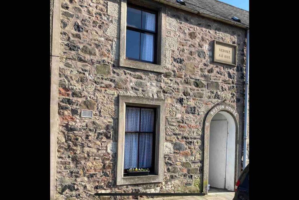 an old stone building with a window and a door at Boston House- Historic house situated in beautiful market town in Duns