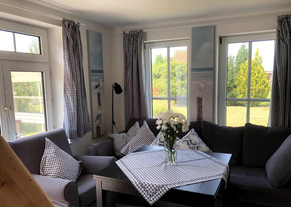 a living room with a couch and a table with flowers at "Kleine 4" Idyllisches TinyHouse an der Nordsee in Norden