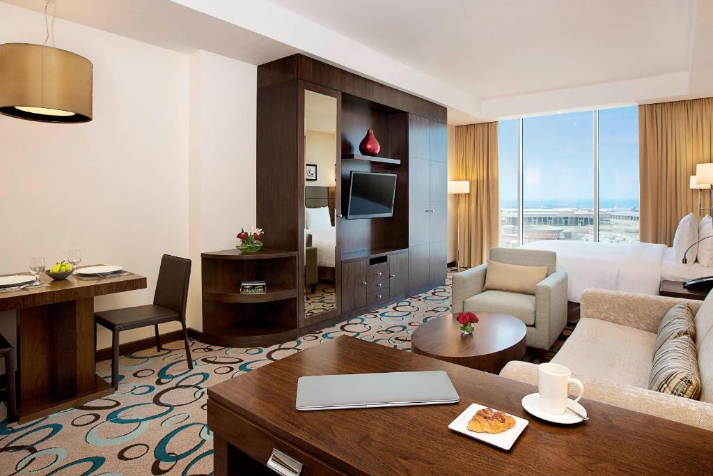 a hotel room with a bed and a living room at Residence Inn by Marriott Jazan in Jazan