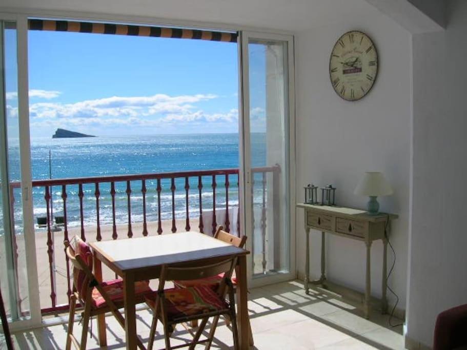Cette chambre dispose d'une table et offre une vue sur l'océan. dans l'établissement Klein cosy appartement met frontaal strand en zeezicht Las Damas, à Benidorm