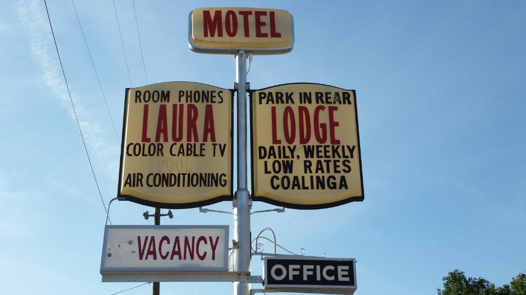 a sign for a motel with many different signs at Laura Lodge in Coalinga