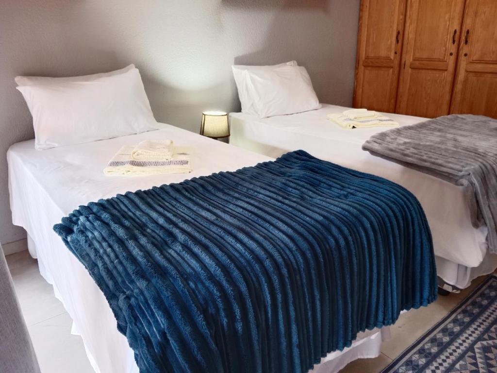 Dos camas en una habitación con una manta azul. en Nakhah Guesthouse - Double Room en Witbank