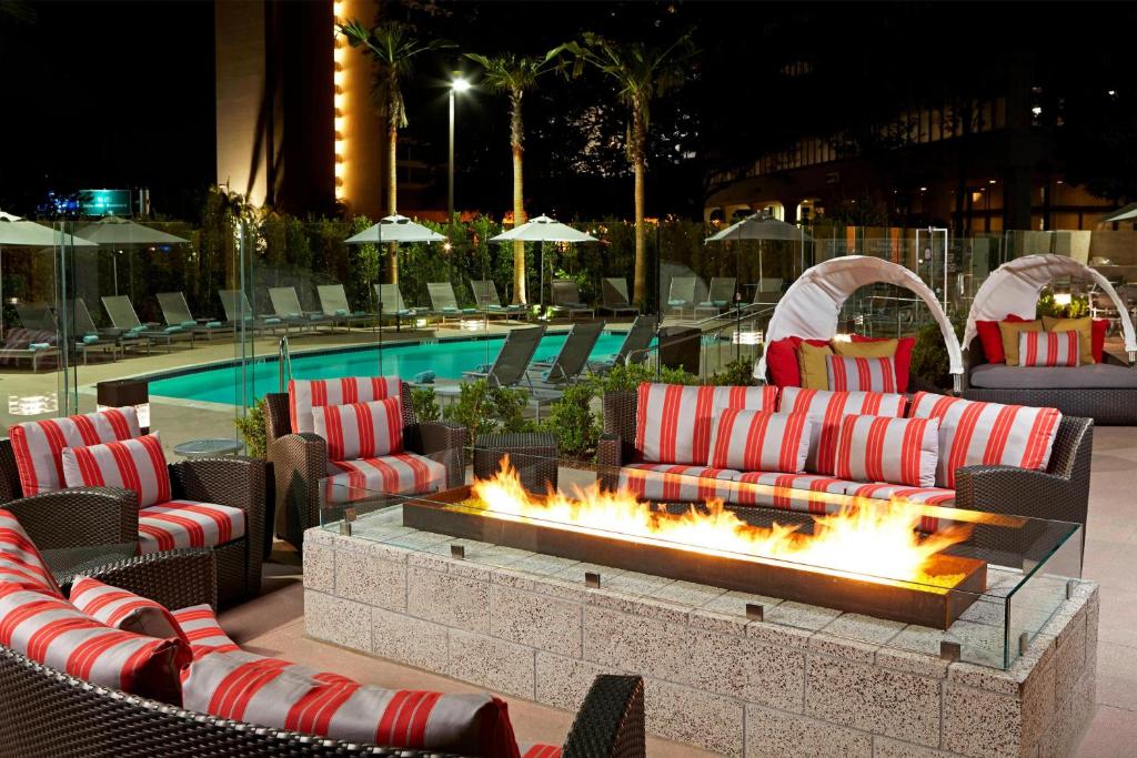 a fire pit with couches and chairs next to a pool at Residence Inn by Marriott Los Angeles LAX/Century Boulevard in Los Angeles