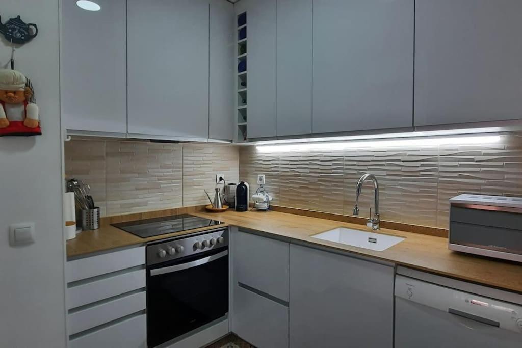 A kitchen or kitchenette at Apartamento con terraza privada, piscina y pkg