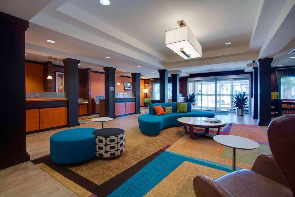 クラモントにあるFairfield Inn & Suites by Marriott Clermontのリビングルーム(青いソファ、テーブル付)