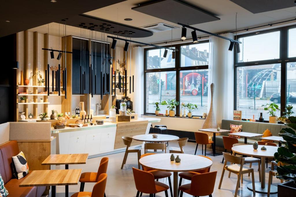 a restaurant with tables and chairs and a large window at Residence Inn by Marriott Dortmund City in Dortmund