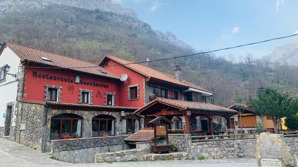 un edificio rojo frente a una montaña en Casa Cuevas, en Caín