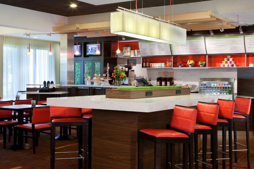 a bar in a restaurant with red bar stools at Courtyard by Marriott Baton Rouge Acadian Centre/LSU Area in Baton Rouge