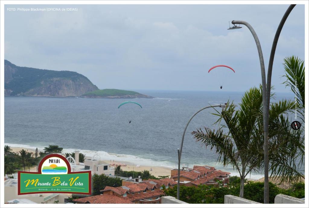 uma vista para uma praia com uma placa e um hotel em Mirante Bela Vista em Niterói
