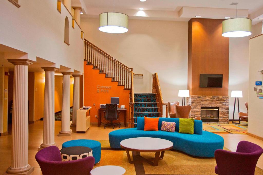 sala de estar con sofá azul y sillas en Fairfield Inn & Suites Modesto, en Modesto