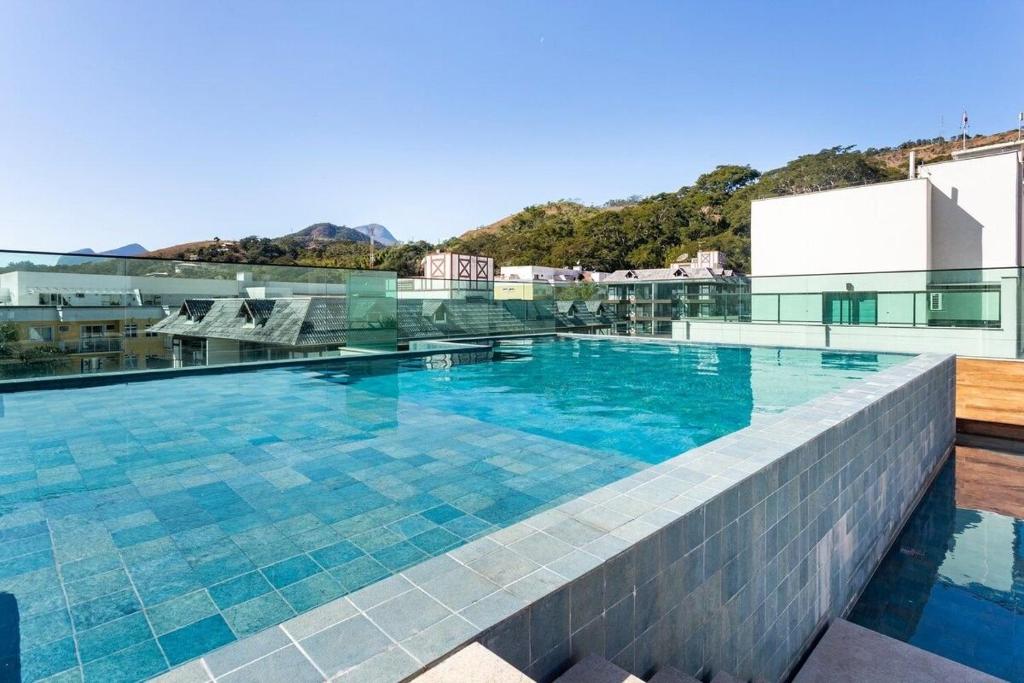 uma piscina no telhado de um edifício em Apto Itaipava, piscina borda infinita, montanha em Itaipava