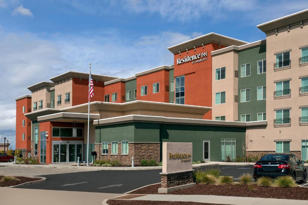 a hotel building with a flag in front of it at Residence Inn by Marriott Modesto North in Modesto