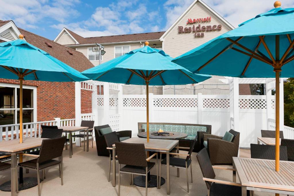 a patio with tables and chairs with blue umbrellas at Residence Inn Rockford in Rockford