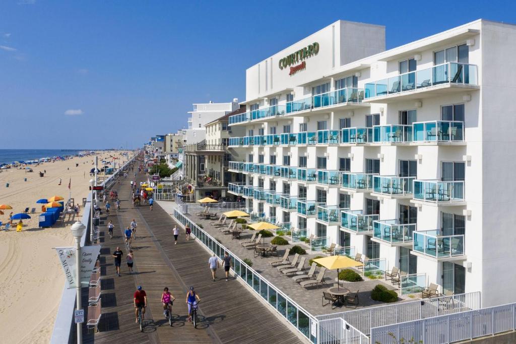 Courtyard by Marriott Ocean City Oceanfront في آوشين سيتي: فندق على الشاطئ بجانب الشاطئ