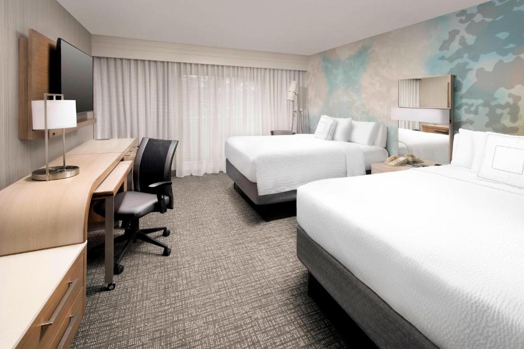 a hotel room with two beds and a desk at Courtyard by Marriott Portland Hillsboro in Hillsboro