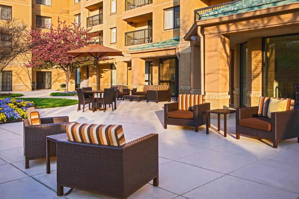 un patio con sillas y mesas y un edificio en Courtyard by Marriott Richmond Northwest, en Henrico
