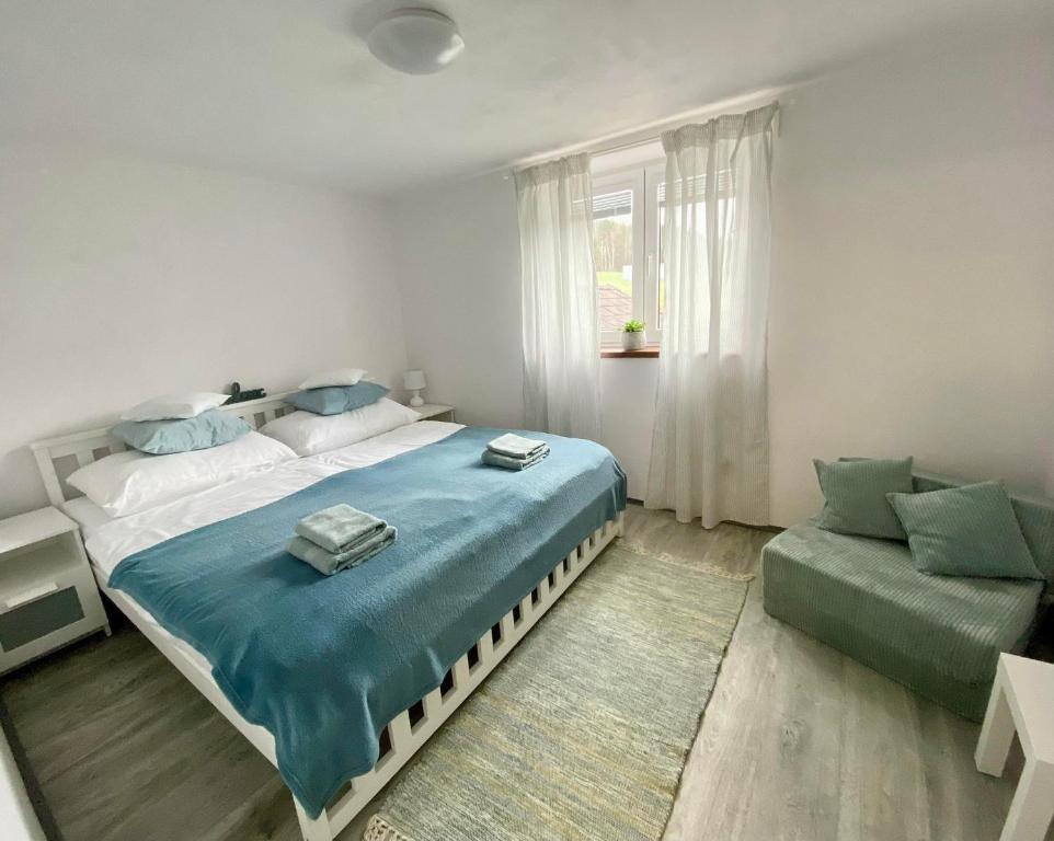 a bedroom with a large bed and a couch at Apartmán Eden in Bystrzyca