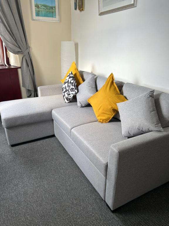 um sofá cinzento com almofadas coloridas na sala de estar em Gables Seaview 4 school Str Largs top floor em Largs