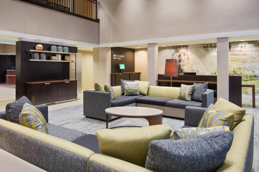 a lobby with couches and chairs and a table at Courtyard by Marriott Springfield Airport in Springfield