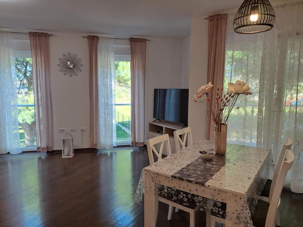 a living room with a table and a television at Apart CENTAR UMAG EDDA Joakima Rakovca 7 E 52470-Umag in Umag