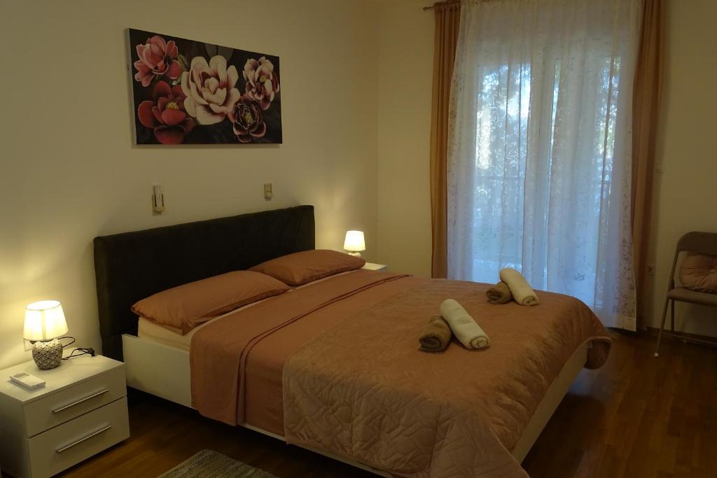 ein Schlafzimmer mit einem Bett mit zwei Hausschuhen darauf in der Unterkunft Apart CENTAR UMAG EDDA Joakima Rakovca 7 E 52470-Umag in Umag