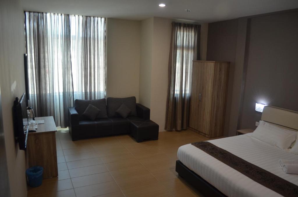 ein Hotelzimmer mit einem Bett und einem Sofa in der Unterkunft Welcome Inn GM in Gua Musang