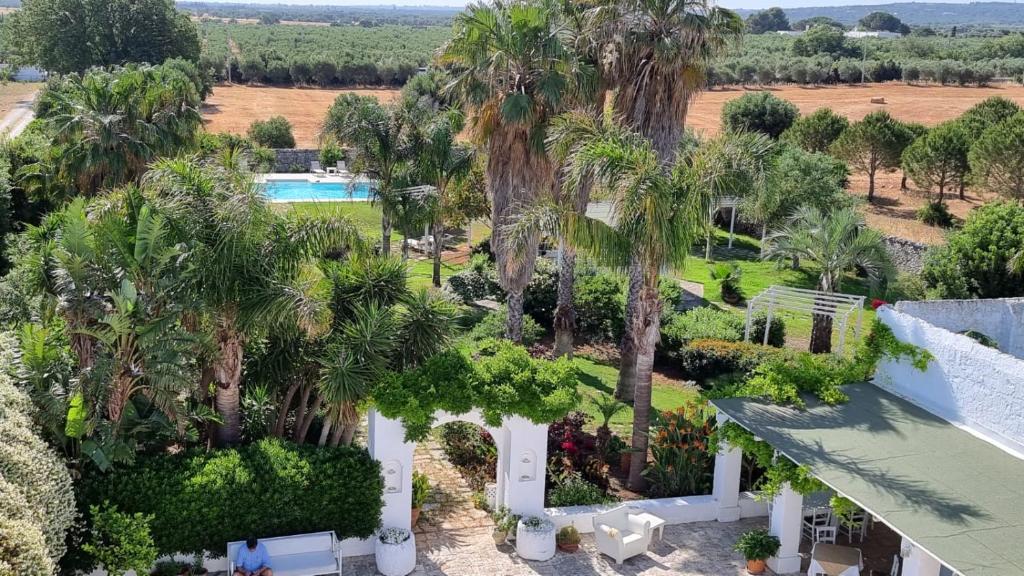 an aerial view of a resort with a pool and palm trees at Masseria Boezio Ostuni Mare in Torre Santa Sabina