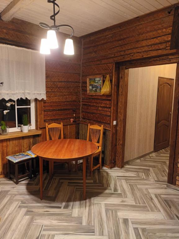 a dining room with a wooden table and chairs at Cidoniju māja 