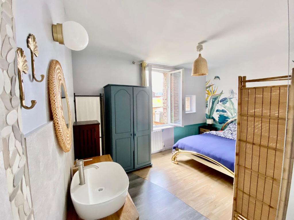 ein Bad mit einem Waschbecken und ein Bett in einem Zimmer in der Unterkunft Bel Appartement pour 2 personnes vue latérale sur le port in Le Tréport