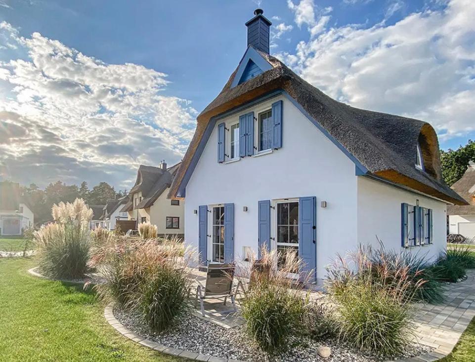 a white house with a thatched roof at Haus Möwenkind in Zirchow