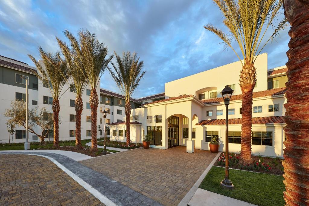 a courtyard with palm trees in front of a building at Residence Inn by Marriott San Diego Chula Vista in Chula Vista