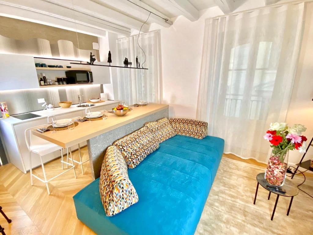 salon z niebieską kanapą i kuchnią w obiekcie 1min da Lago e Duomo Prestigioso appartamento w Como