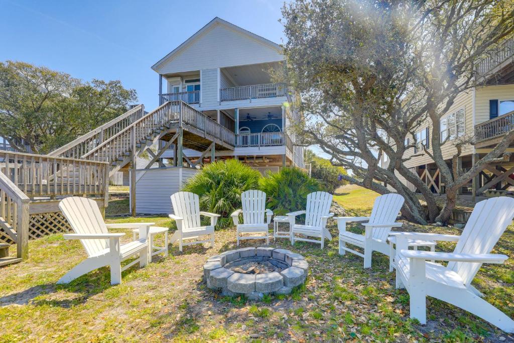 a group of white chairs around a fire pit in front of a house at Waterfront Emerald Isle Home with Dock Access! in Emerald Isle
