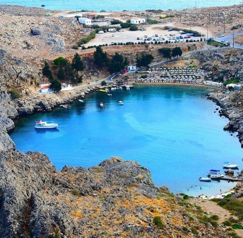 un gran cuerpo azul de agua con barcos dentro en Fedra Apartments Lindos, en Lindos