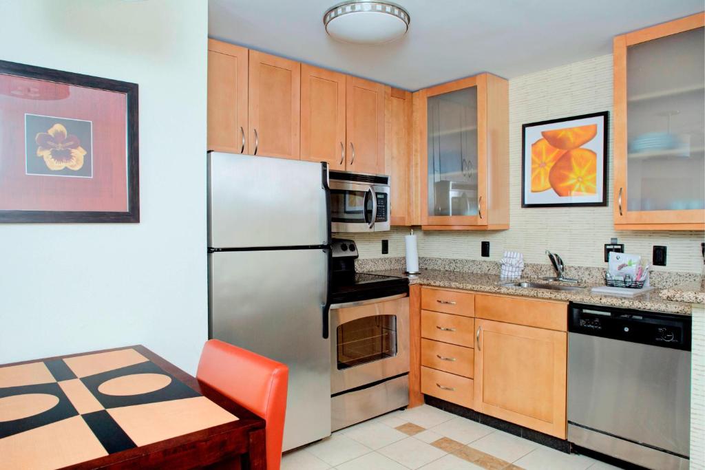 a kitchen with wooden cabinets and a stainless steel refrigerator at Residence Inn by Marriott Richmond Chester in Woodvale