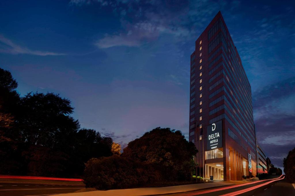 ein hohes Gebäude mit einem Schild davor in der Unterkunft Delta Hotels by Marriott Richmond Downtown in Richmond