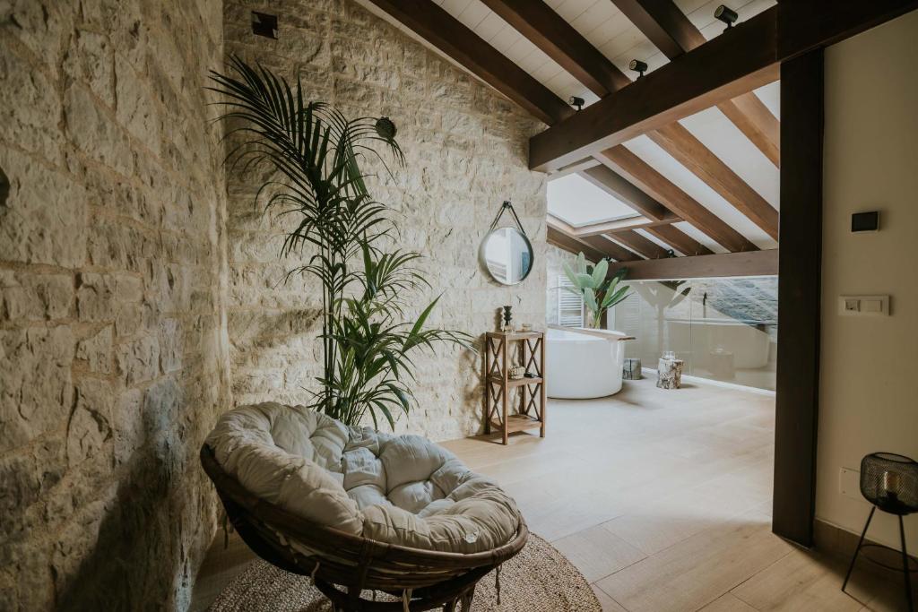 a living room with a couch in a stone wall at Puracepa - Urban Suites in Haro