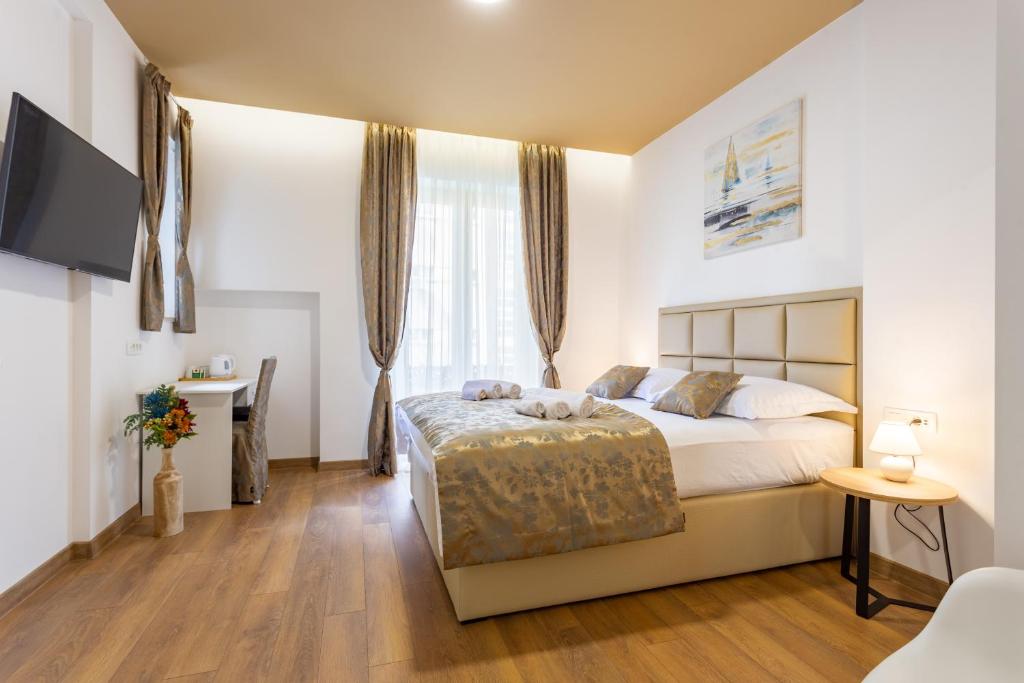 Schlafzimmer mit einem Bett, einem Schreibtisch und einem TV in der Unterkunft Luxury Rooms Fetivi in Split