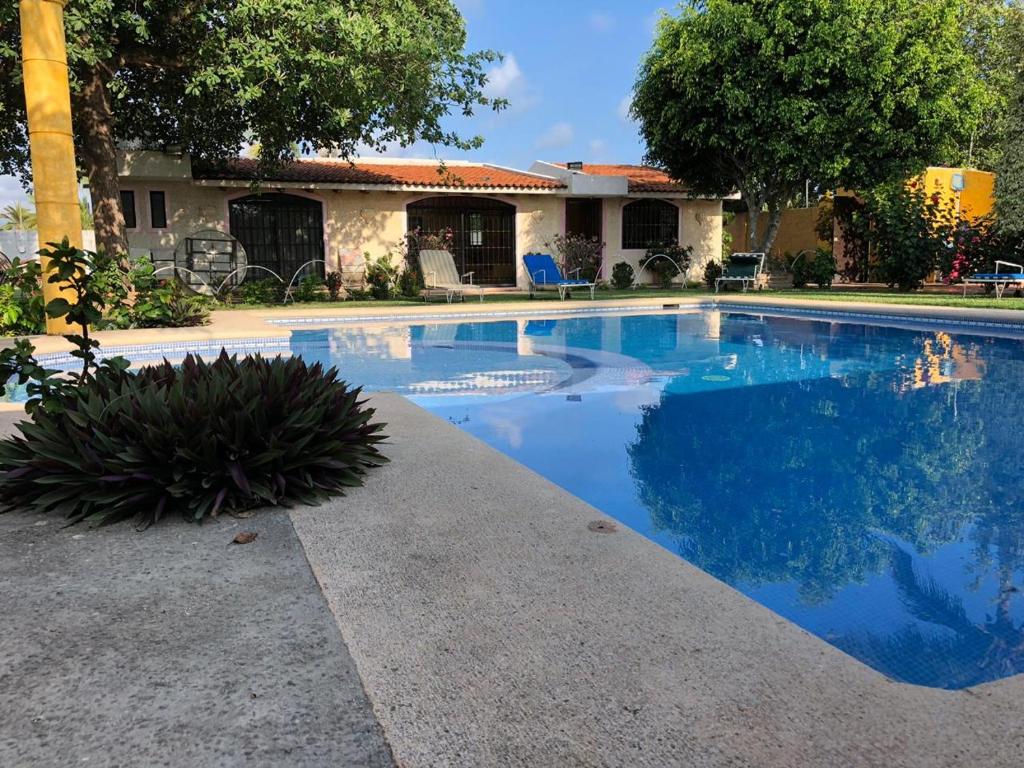 a swimming pool in front of a house at Hermosa Casa Ikal en Acapulco in Barra de Coyuca