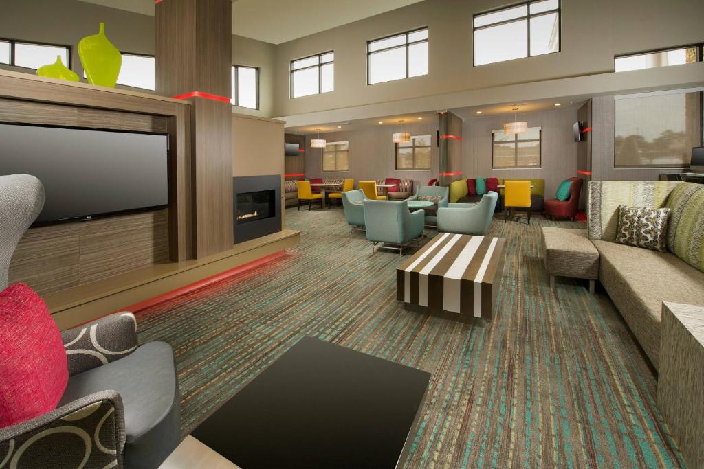 a lobby with a waiting room with couches and a tv at Residence Inn by Marriott Tyler in Tyler