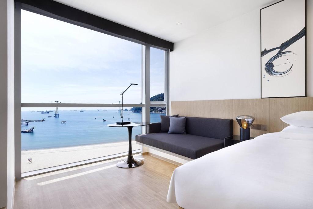 a bedroom with a bed and a view of the ocean at Fairfield by Marriott Busan Songdo Beach in Busan