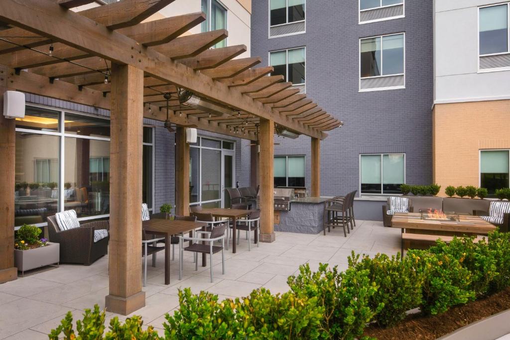 a patio with tables and chairs in front of a building at Towneplace Suites By Marriott Louisville Northeast in Louisville